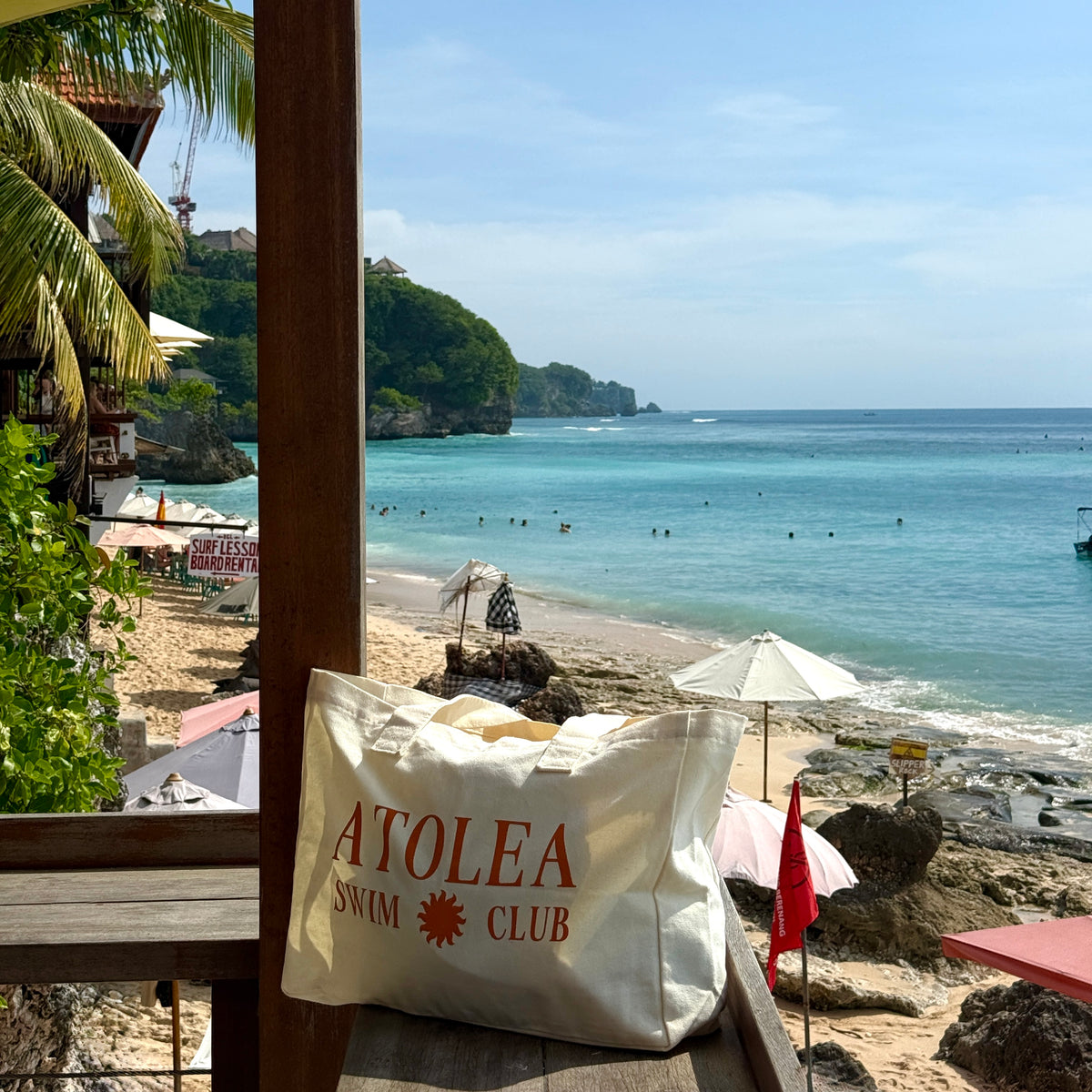 Atolea canvas beach tote bag hanging on a beach terrace with ocean view