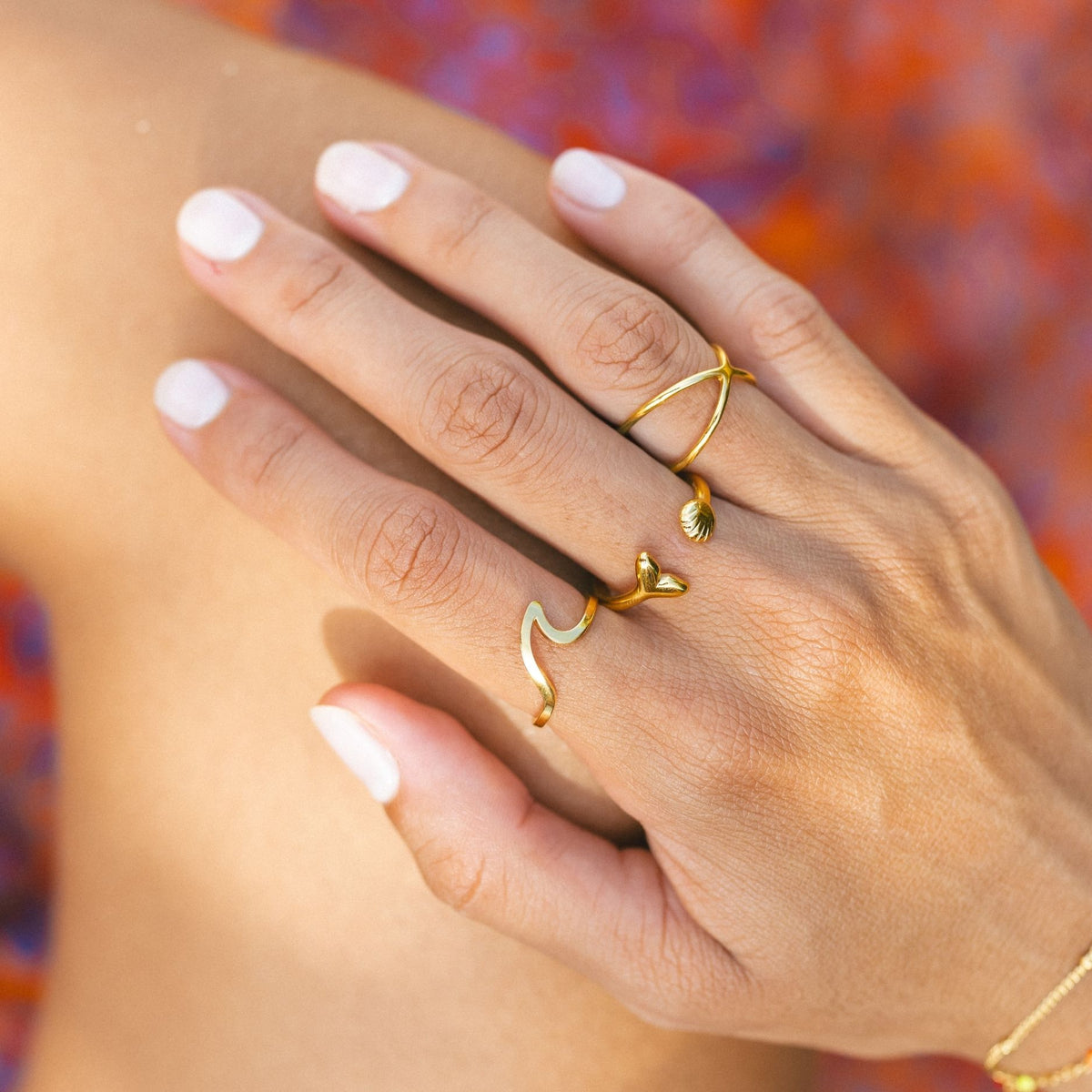 Golden sun rings in gold worn stacked on the hand